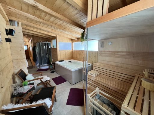 Moderne Sauna mit Holzverkleidung, Entspannungsbereich und Whirlpool.